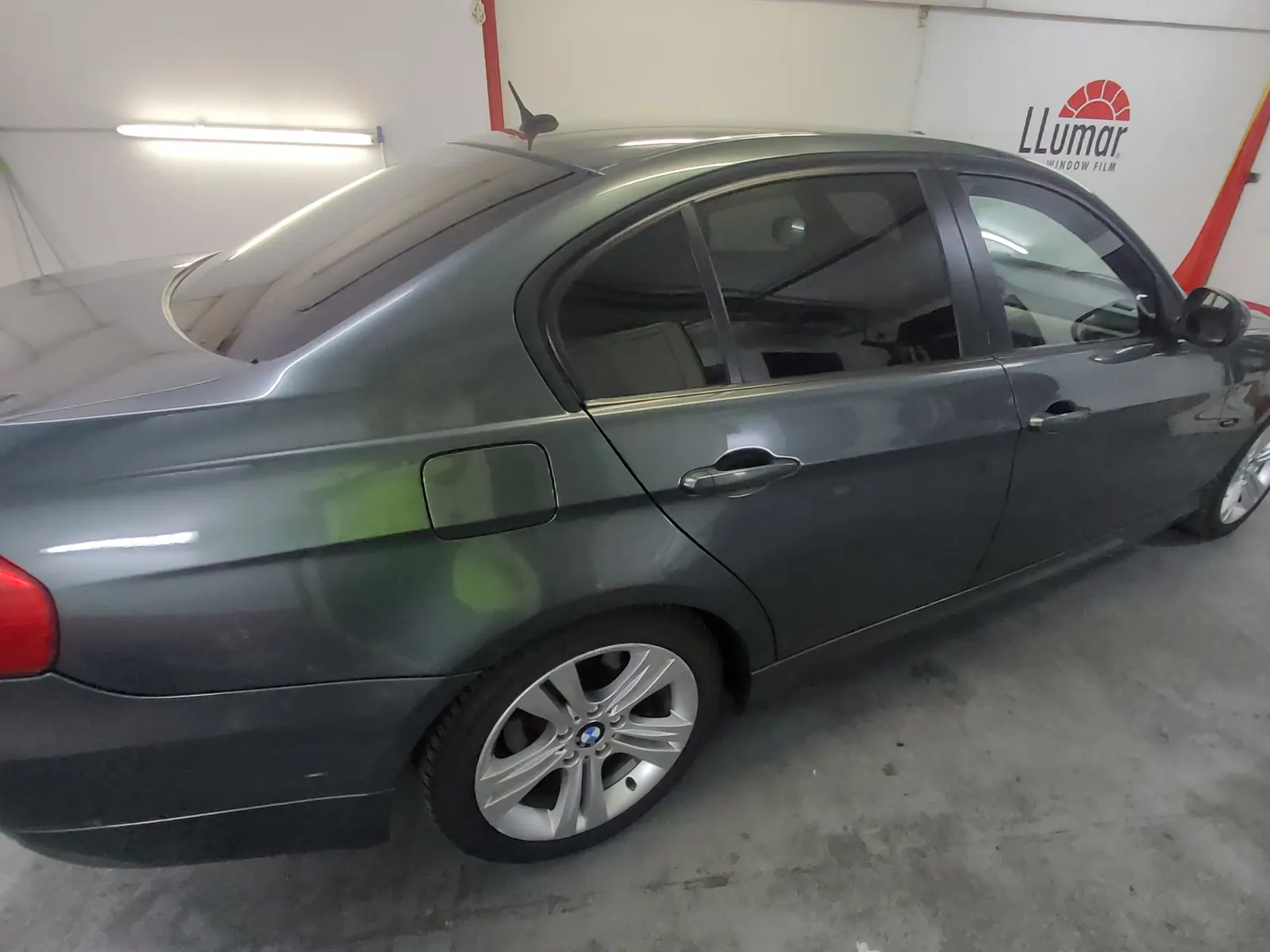 Detaliu folie fumurie LLumar ATR05 pe luneta BMW E90 verde